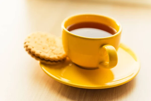 Té en taza amarilla y galleta —  Fotos de Stock