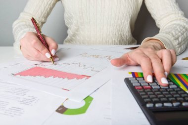 Kalem, siyah hesap makinesi ve sayfaları ile eller