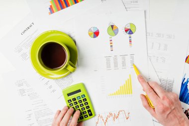 Closeup işadamı diyagramı kahve Kupası ile office tabloda belgeleriyle çalışma