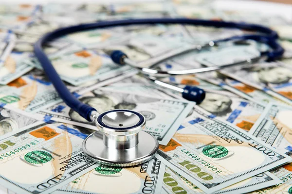 Closeup of Dollars with stethoscope. Costs for medical insurance.