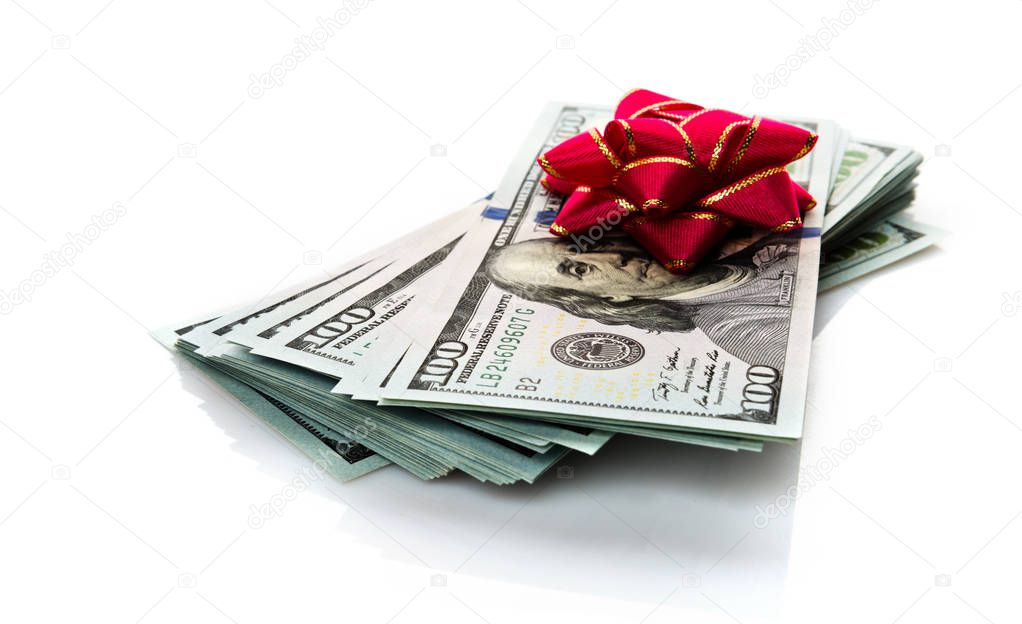 Stack of American money with red bow isolated on white background