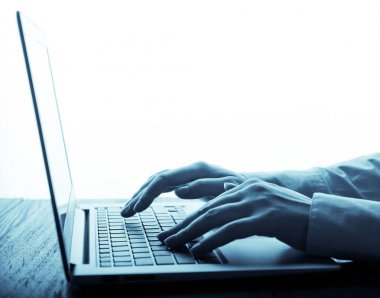 Dizüstü bilgisayarda çalışan insan elleri