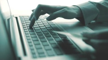 Bir kredi kartı tutan ve online shoppin için dizüstü bilgisayar kullanan eller