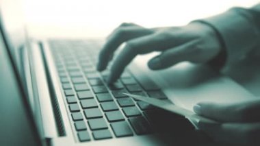 Bir kredi kartı tutan ve online shoppin için dizüstü bilgisayar kullanan eller