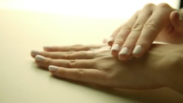 gyönyörű nő kezet alkalmazása krém a bőr, manikűr közelről 