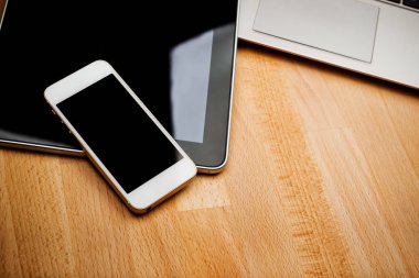 Ahşap masa üzerinde smartphone ve tablet bilgisayar ile dizüstü bilgisayar