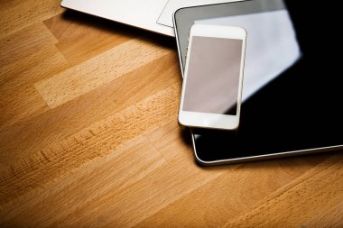 Ahşap masa üzerinde smartphone ve tablet bilgisayar ile dizüstü bilgisayar