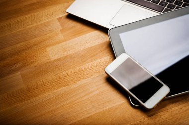 Ahşap masa üzerinde smartphone ve tablet bilgisayar ile dizüstü bilgisayar
