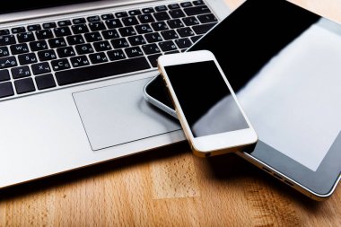 Ahşap masa üzerinde smartphone ve tablet bilgisayar ile dizüstü bilgisayar