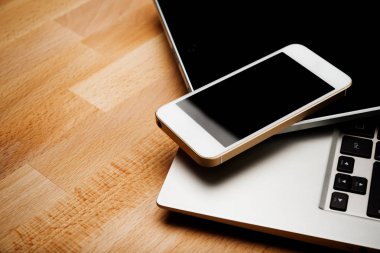 Ahşap masa üzerinde smartphone ve tablet bilgisayar ile dizüstü bilgisayar