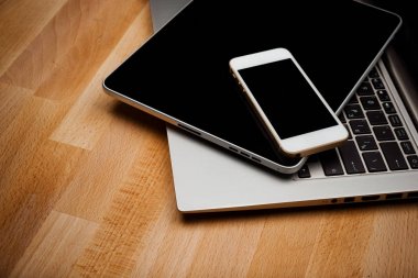 Ahşap masa üzerinde smartphone ve tablet bilgisayar ile dizüstü bilgisayar