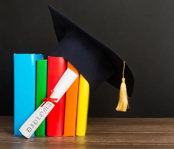 Mörtelbrett Und Graduiertenrolle Auf Stapel Bunter Bücher — Stockfoto