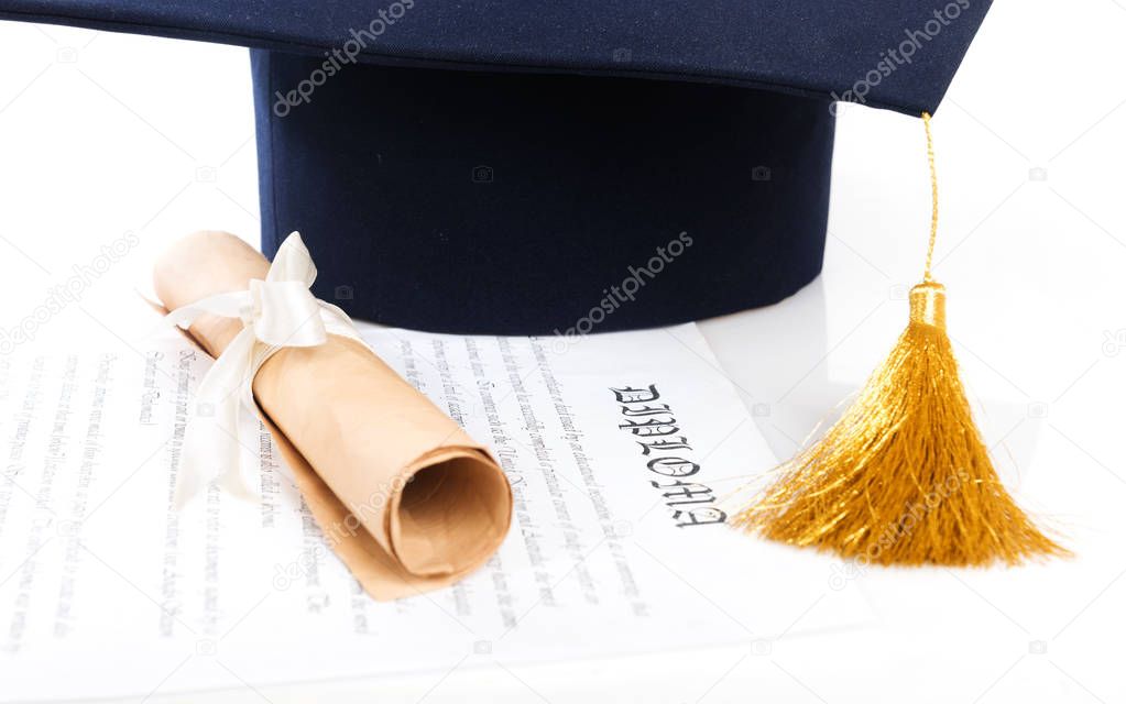 Graduation hat and Diploma on white surface