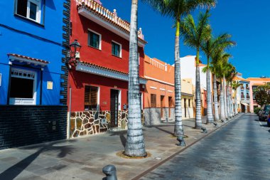 Puerto de la Cruz caddesinde renkli evler ve palmiye ağaçları.