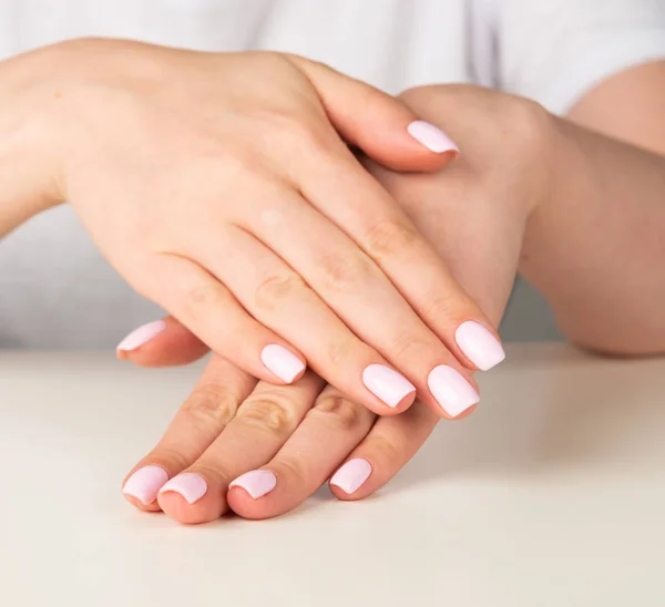 Красивая женская рука с светло-розовым дизайном ногтей — стоковое фото