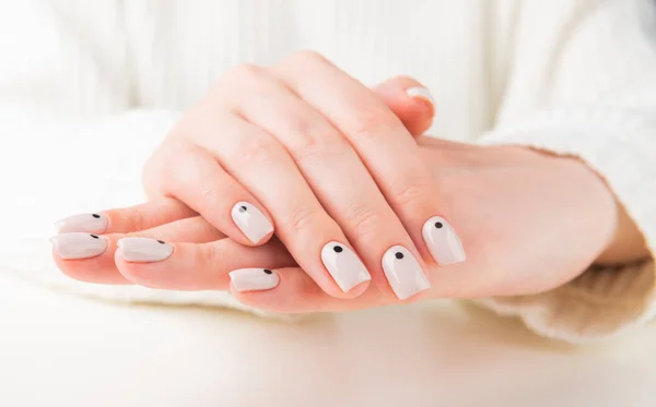 Mão com manicure bege com design de unhas pontos — Fotografia de Stock