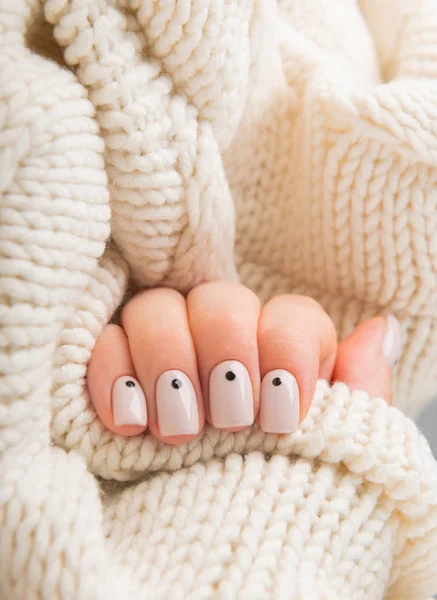 Snygga beige naglar med prickar håller stickad ull materia — Stockfoto