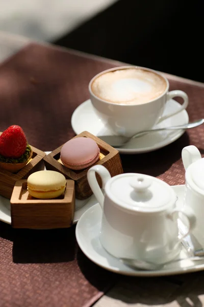 Taza de capuchino y macarrones — Foto de Stock