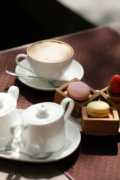 Kopp cappuccino och macarons — Stockfoto