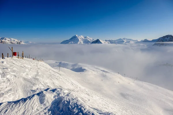 Montagnes dans les nuages bas avec de la neige en hiver — Photo