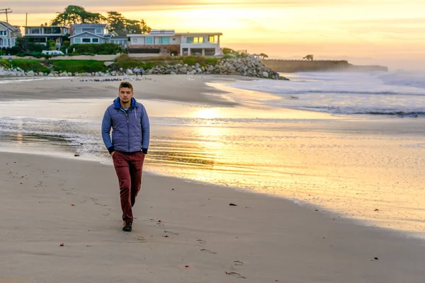 Самотній чоловік на пляжі на сході сонця — стокове фото