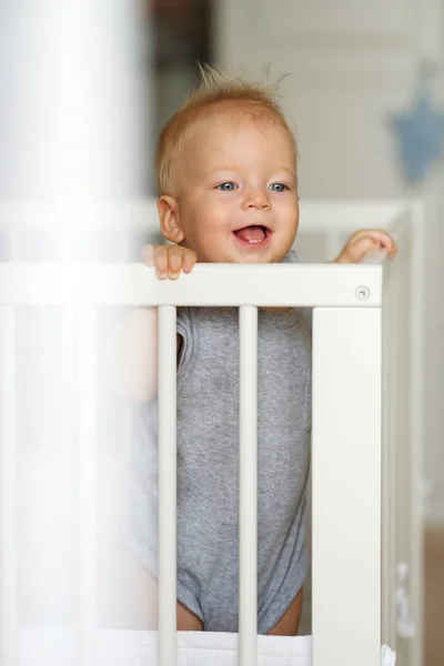 Малыш стоит в кроватке — стоковое фото