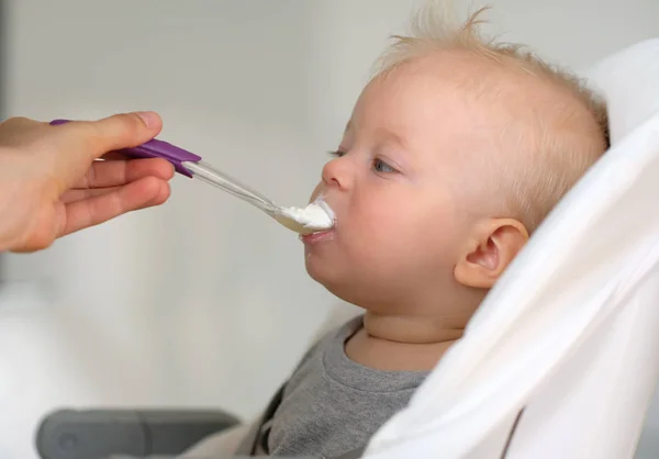 Mata barnet med sked — Stockfoto