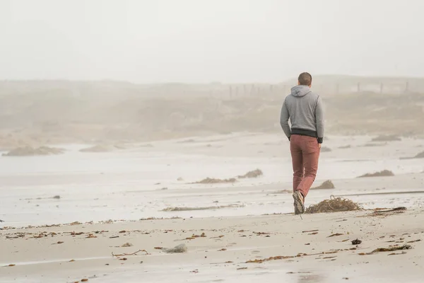 Homme marchant le long de la plage — Photo