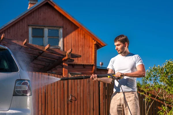 Man tvätta bilen framför huset — Stockfoto