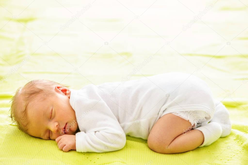 newborn baby sleeping in bed