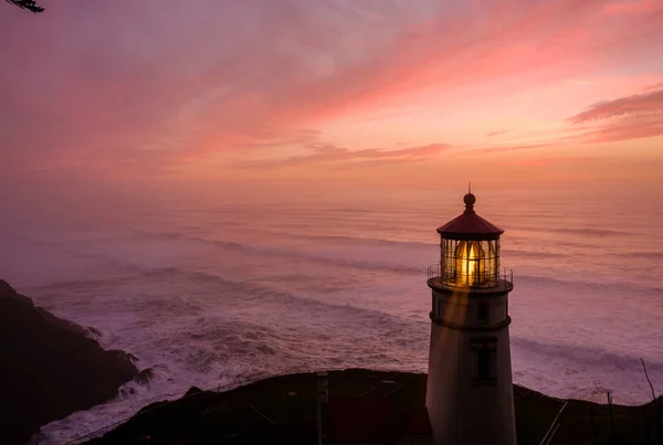 Lighthouse at sunset above ocean — Stock Photo, Image