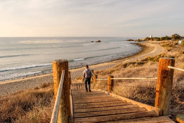 Mężczyznę idącego w boardwalk do plaży — Zdjęcie stockowe