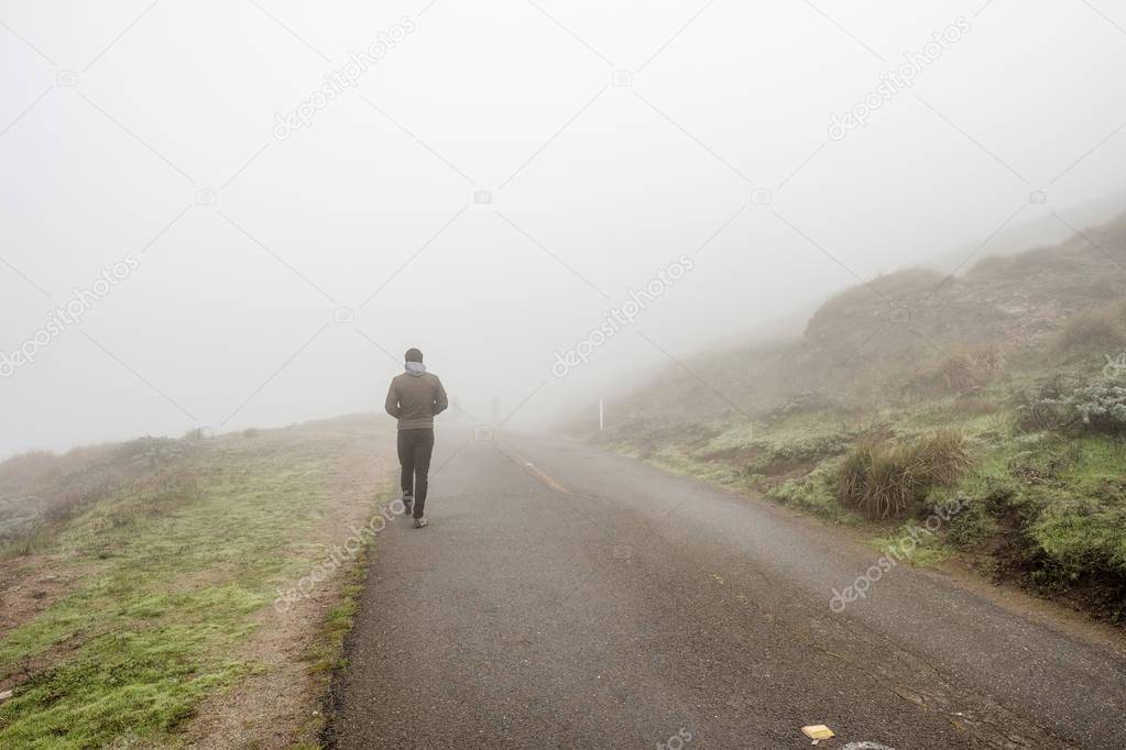 man walking through fog