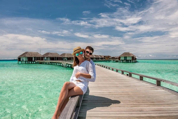 Casal em branco em um molhe de praia em Maldivas — Fotografia de Stock