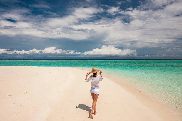 Vrouw met hoed van de zon op tropisch strand — Stockfoto