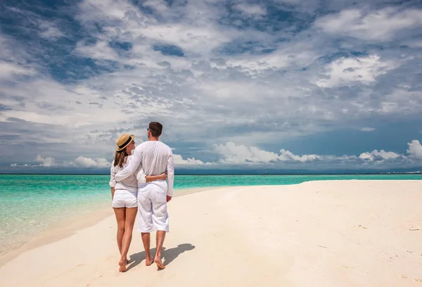 Paar in Weiß spaziert am Strand — Stockfoto