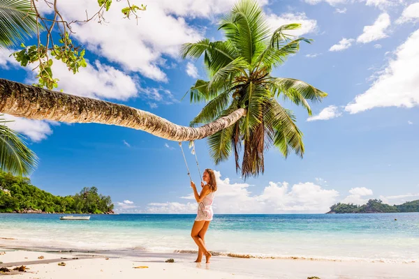 Femme en robe bleue balançant à la plage — Photo