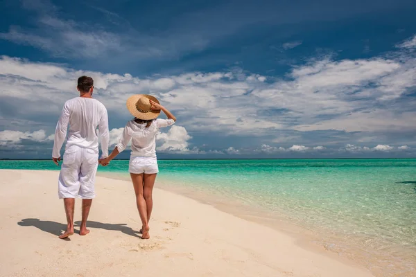 Couple en blanc marchant sur une plage — Photo
