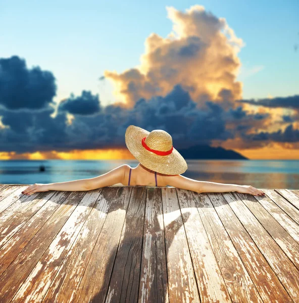 Γυναίκα με καπέλο χαλαρώνοντας στην παραλία — Φωτογραφία Αρχείου