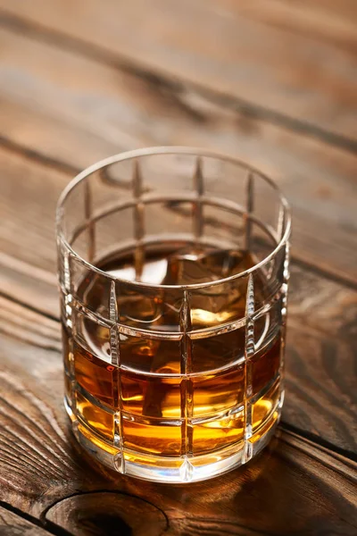 Verre de whisky avec glaçons sur table en bois — Photo