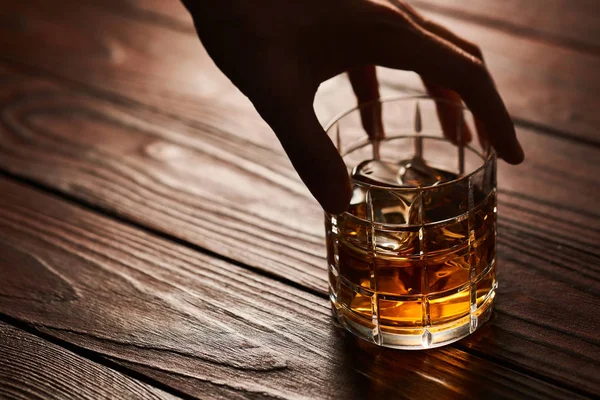 Glas whisky met ijsblokjes op houten tafel — Stockfoto