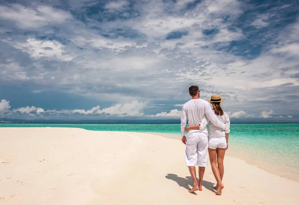 Coppia in bianco passeggiando su una spiaggia alle Maldive — Foto Stock
