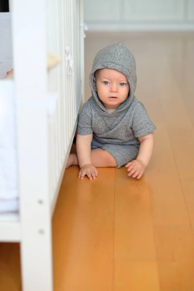 Дитячий хлопчик сидить на дерев'яній підлозі — стокове фото