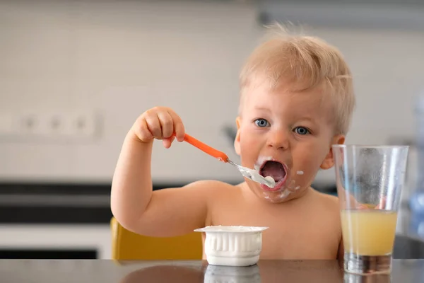 Messy baby eating with spoon — Stock Photo, Image