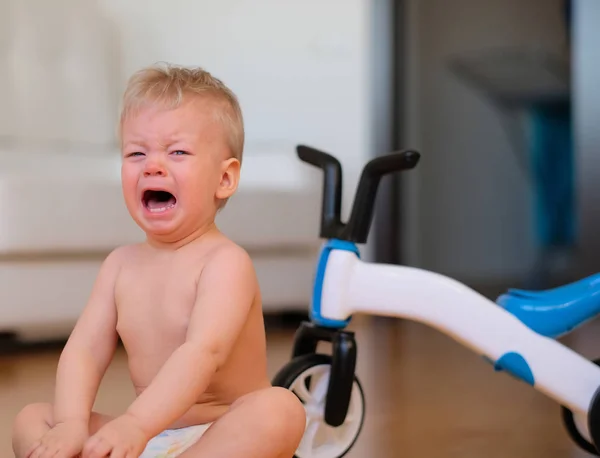 Baby pojke gråter sitter på golvet — Stockfoto