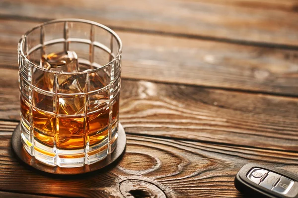 Glas whiskey med isbitar och bilnyckel — Stockfoto