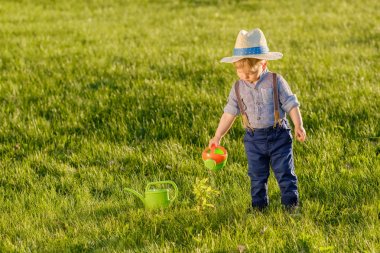 sulama olabilir kullanarak hasır şapka giyen çocuk