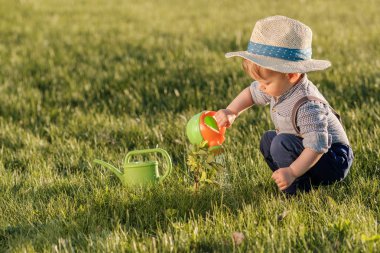 sulama olabilir kullanarak hasır şapka giyen çocuk