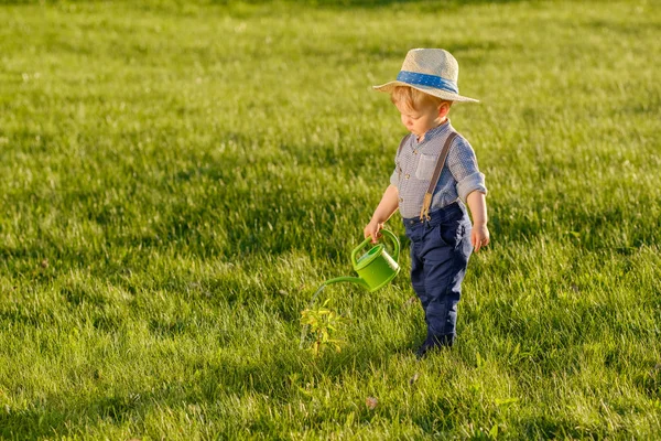 Anak laki-laki mengenakan topi jerami menggunakan kaleng air — Stok Foto