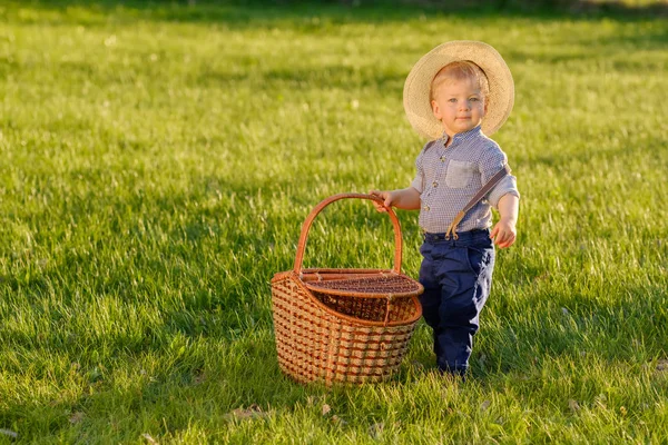 piknik sepeti tutan hasır şapka giyen çocuk